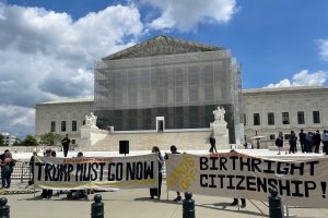 Protesters holding up anti-Trump banners in front of the Supreme Court